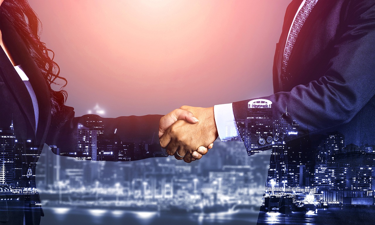 Two professionals shaking hands against a city skyline